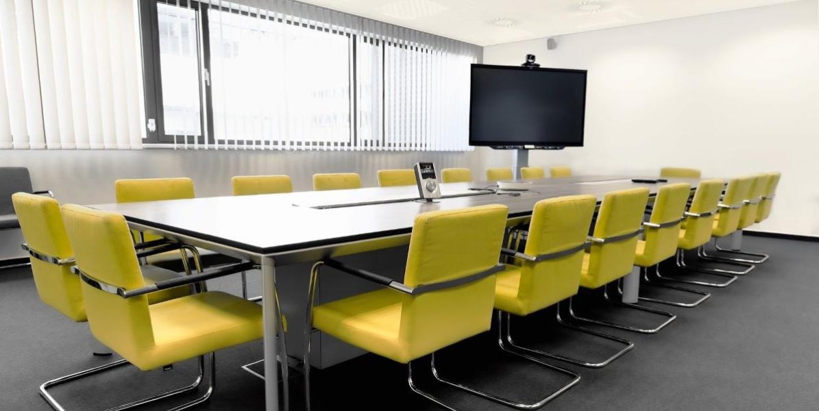 Meeting room with large table and yellow chairs Meeting room with large table and yellow chairs